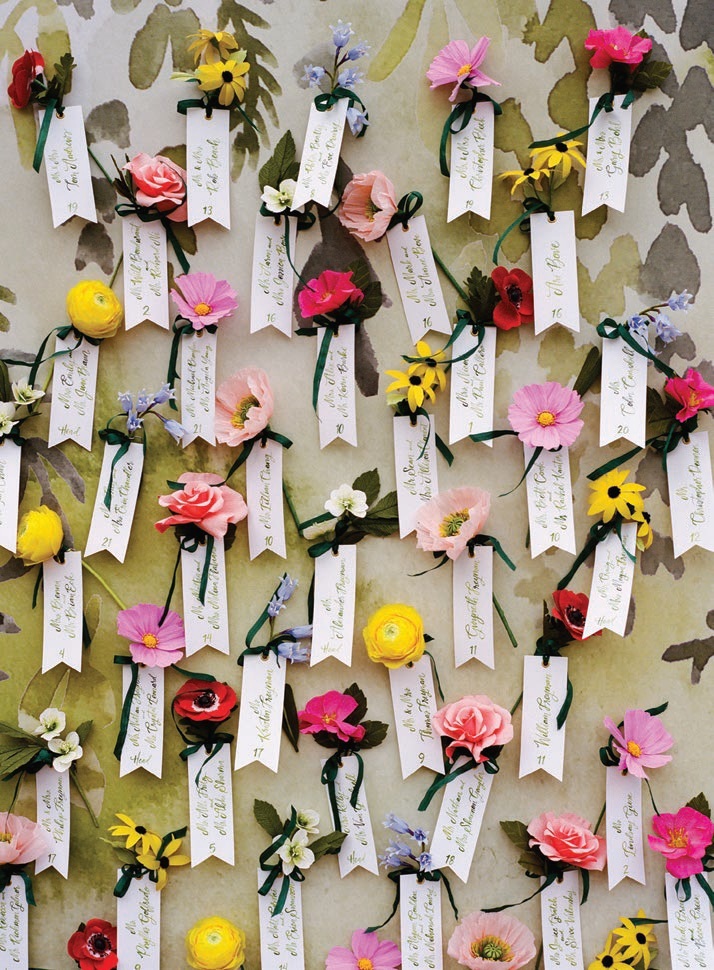 Place cards were tied up with paper flowers Photographed by Liz Banfield