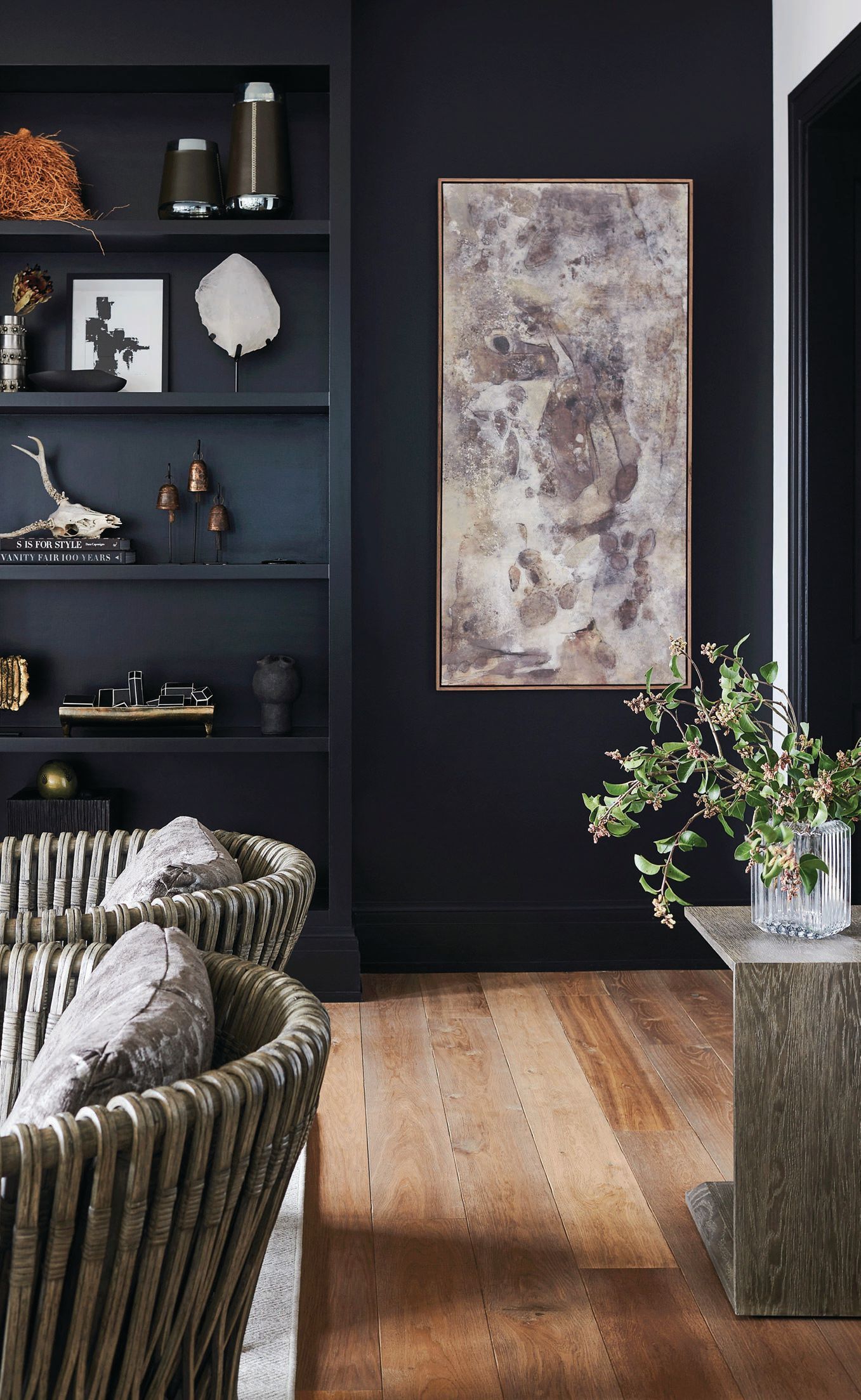 In the living room, Benjamin Moore’s Black Beauty sets a stylish scene with Arteriors Strata chairs, the artwork “Penumbra II” by Matera and shelves brimming with smartly curated accessories. Photographed by Anthony Tahlier