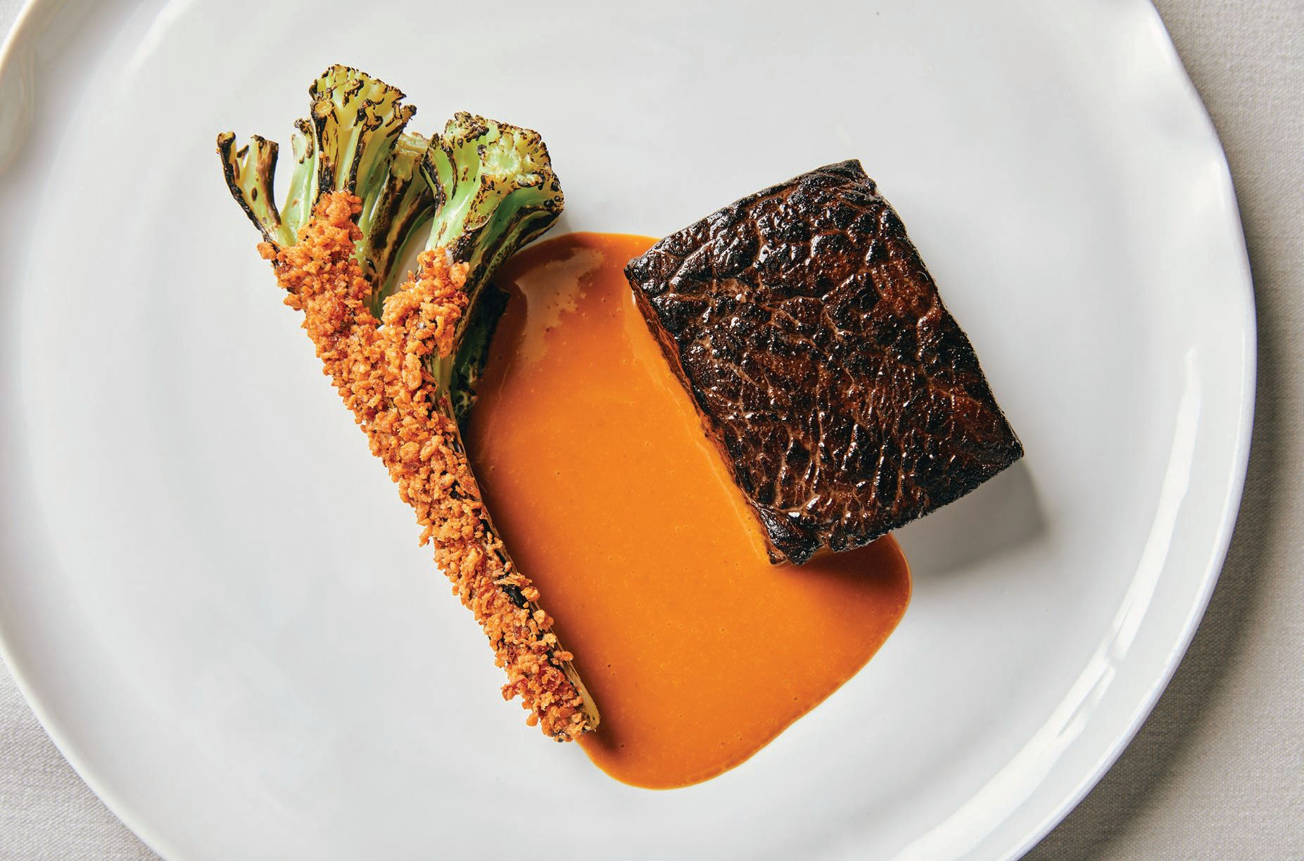 Aged Midwestern beef with caramelized carrot and miso butter and charred brassicas PHOTO BY JACLYN RIVAS