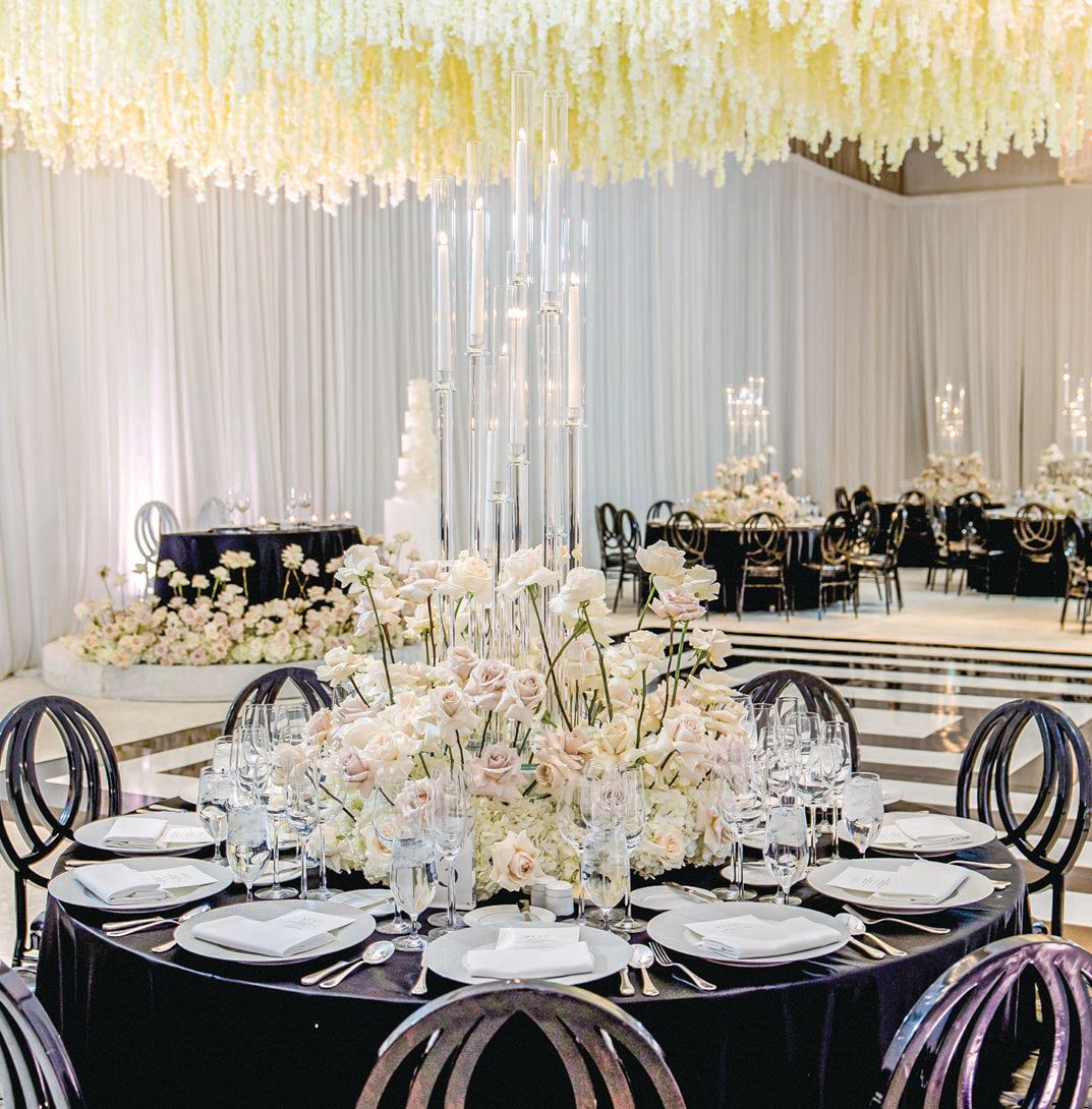 Centerpieces starred blush- and neutral-hued flowers and tall candelabras, and an incredible white floral installation hung over the dance floor Photographed by Imagery by Jules Photography