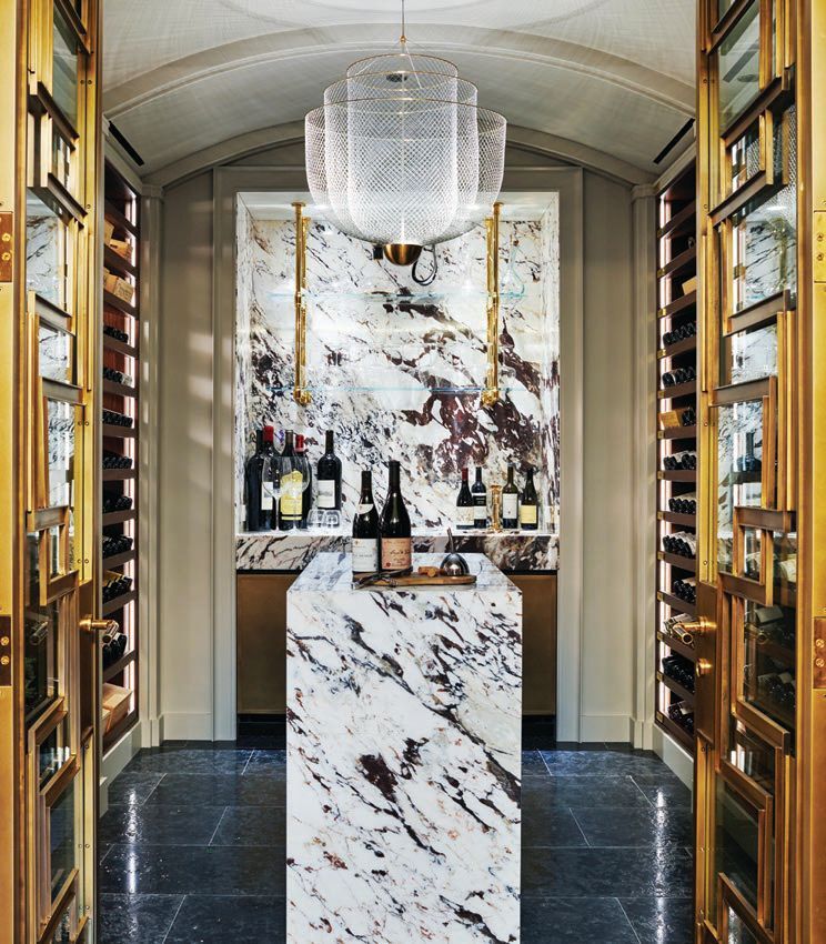 The wine vault beckons with a waterfall island in Prunella marble by Waterworks and Bleu Fonce tile by Chadwick's Surfaces International. Photographed by Richard Powers