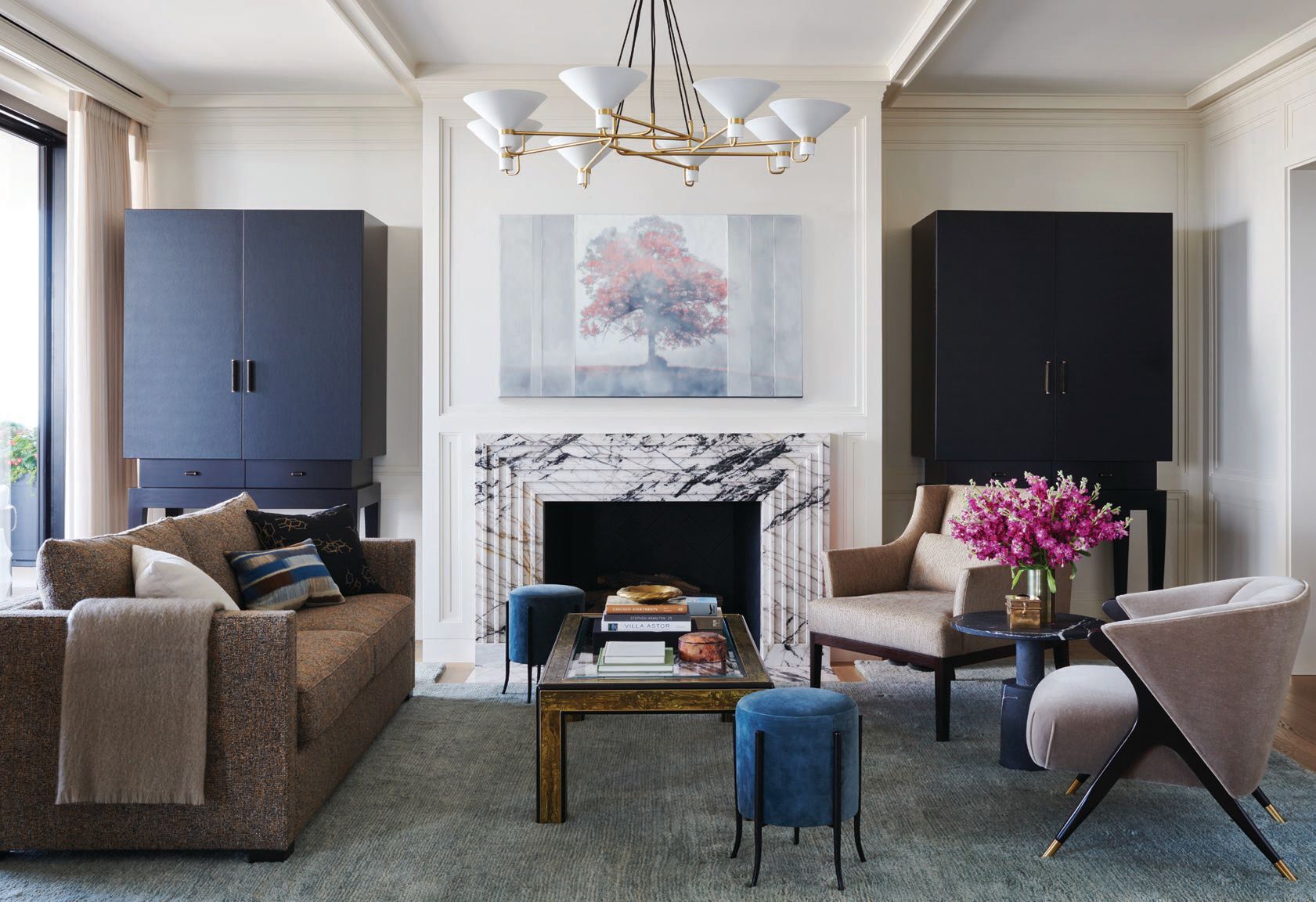 The library is anchored by a Mastercraft acid-etched brass and black lacquer coffee table by Bernhard Rohne, Jonathan Browning Studios' Lauriston circular chandelier and artist Tom Brydelsky's work "Tree with Red Leaves," sourced from Gruen Galleries Photographed by Richard Powers