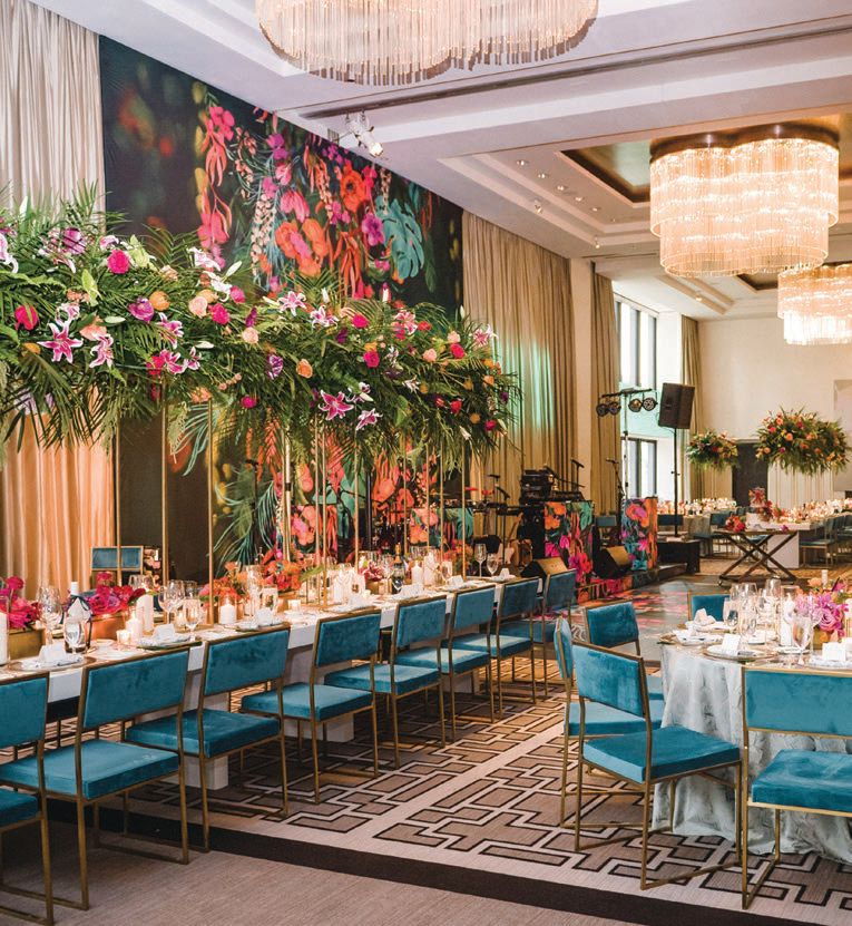 The focal point of the decor was a tropiclal graphic print that covered the dance floor and extended up the wall, and tall junglelike centerpieces made it even more immersive Photographed by Amanda Megan Miller