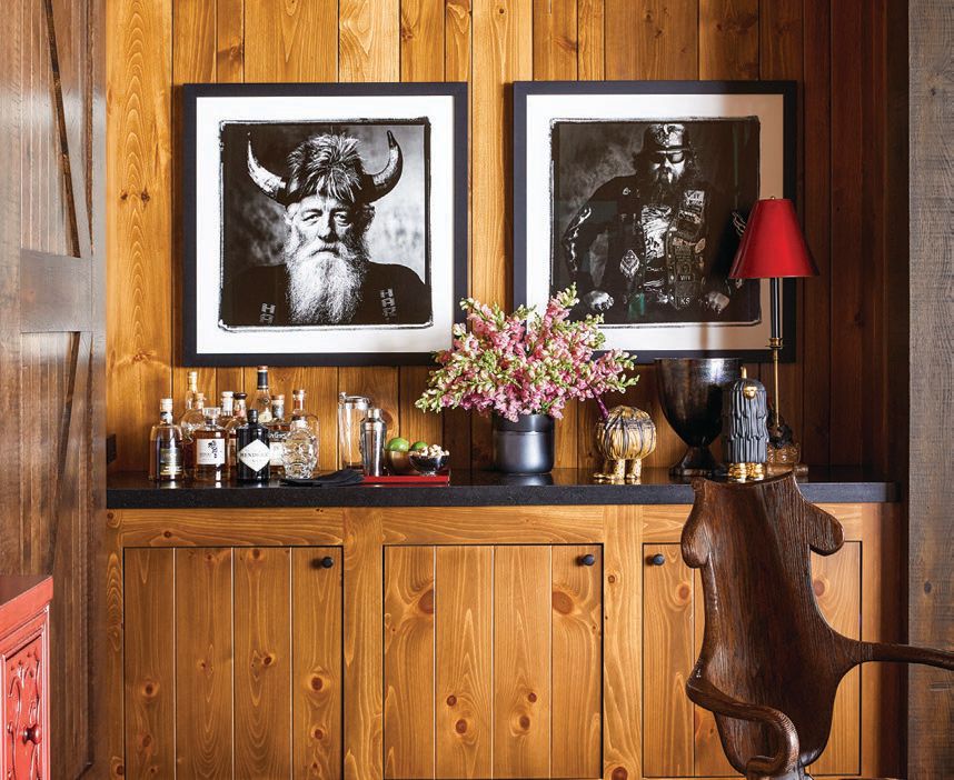 Photographs by Sandro Miller hang above a Henley arm chair in oak with a rush seat by Rose Tarlow. PHOTOGRAPHED BY ERIC PIASECKI