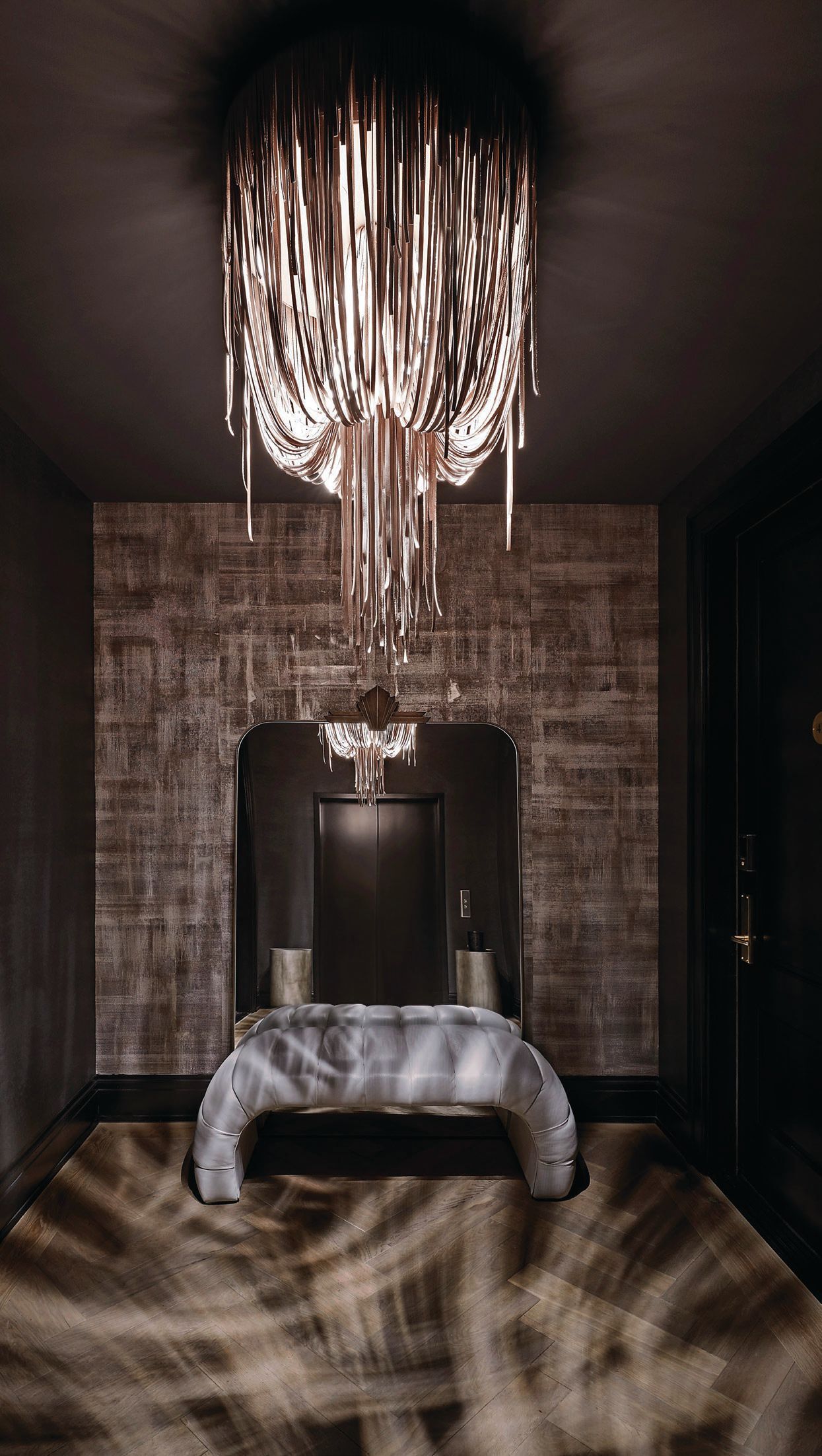 Ngala Trading’s Urchin chandelier in champagne metallic leather plus Studio BK’s Broken Metal wallpaper add up to a showstopping first impression in the elevator entry vestibule. Photographed by Anthony Tahlier