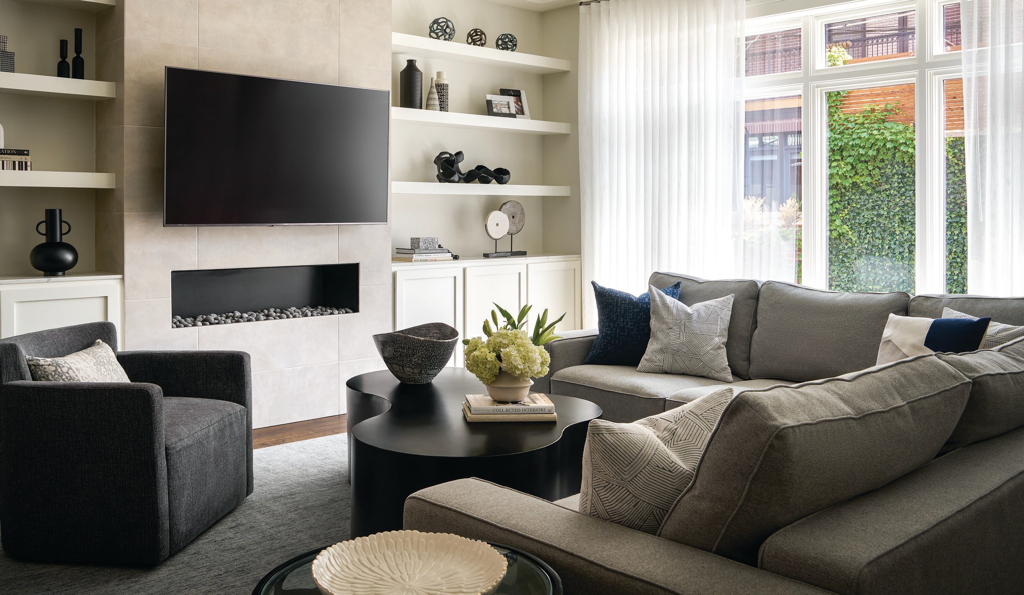 In the family room, Interior Define’s Ainsley sectional, Noir Furniture’s Island coffee table in black steel and a custom armchair by Eurocraft Inc. set a comfortable scene. PHOTOGRAPHED BY RYAN MCDONALD