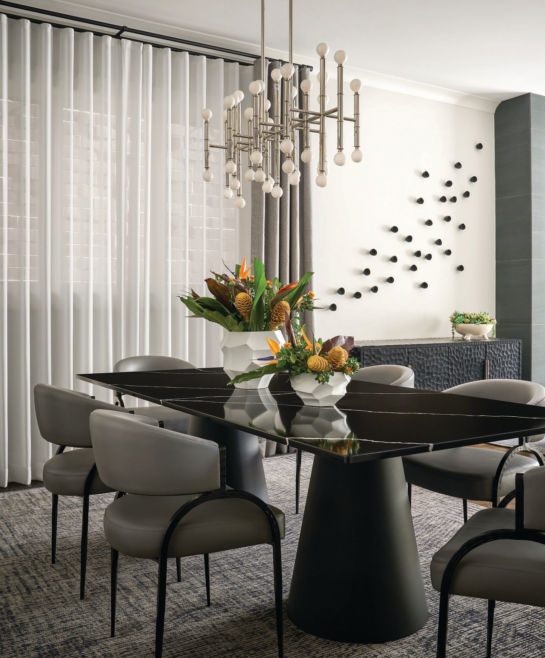 A Meurice chandelier by Jonathan Adler, Arteriors chairs and a polished Vicostone Nero Marquina dining table with custom base fabricated by Tithof Tile & Marble star in the dining room. PHOTOGRAPHED BY RYAN MCDONALD