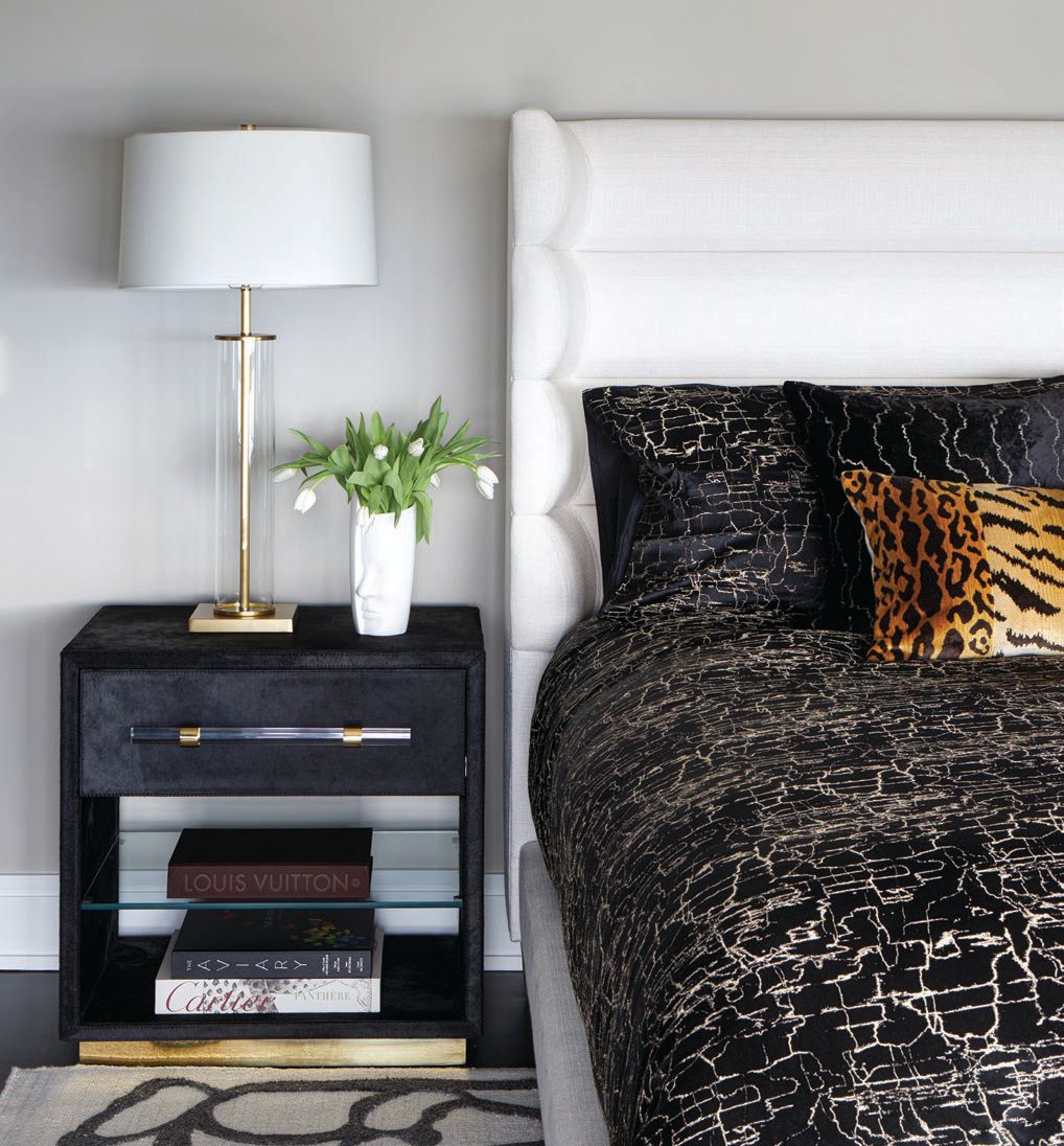 An Interlude nightstand pairs with the exotic Horchow pillows and floor covering sourced from Exquisite Rugs in the primary bedroom. PHOTOGRAPHED BY MICHAEL ALAN KASKEL