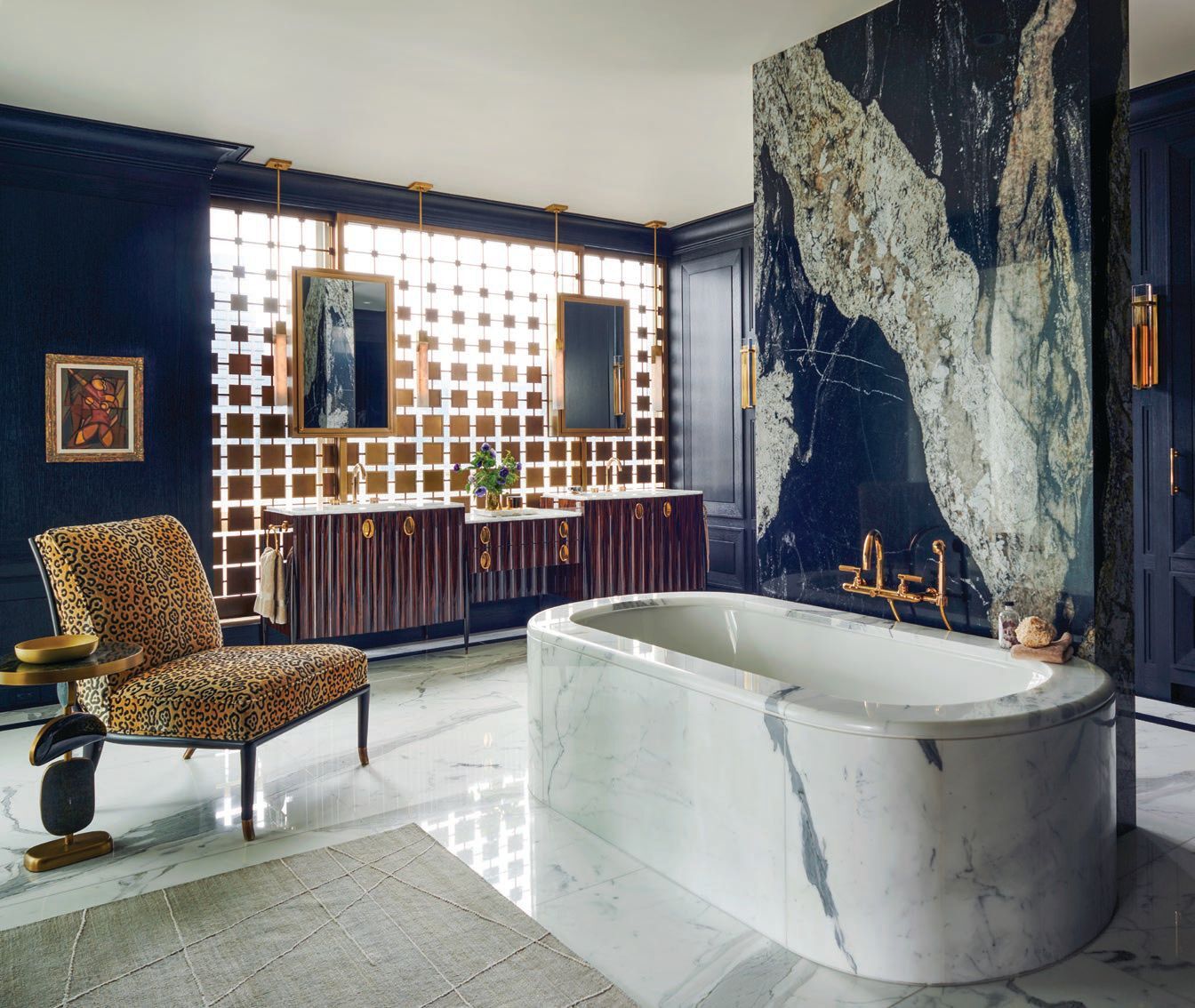 The primary bath is a feast for the eyes, boasting an MTI tub with custom marble shroud and slab wall fabricated by SIMI Stone, leopard print Brou chair by Alfonso Marina and custom vanity designed by Soucie Horner Interiors Photographed by Richard Powers