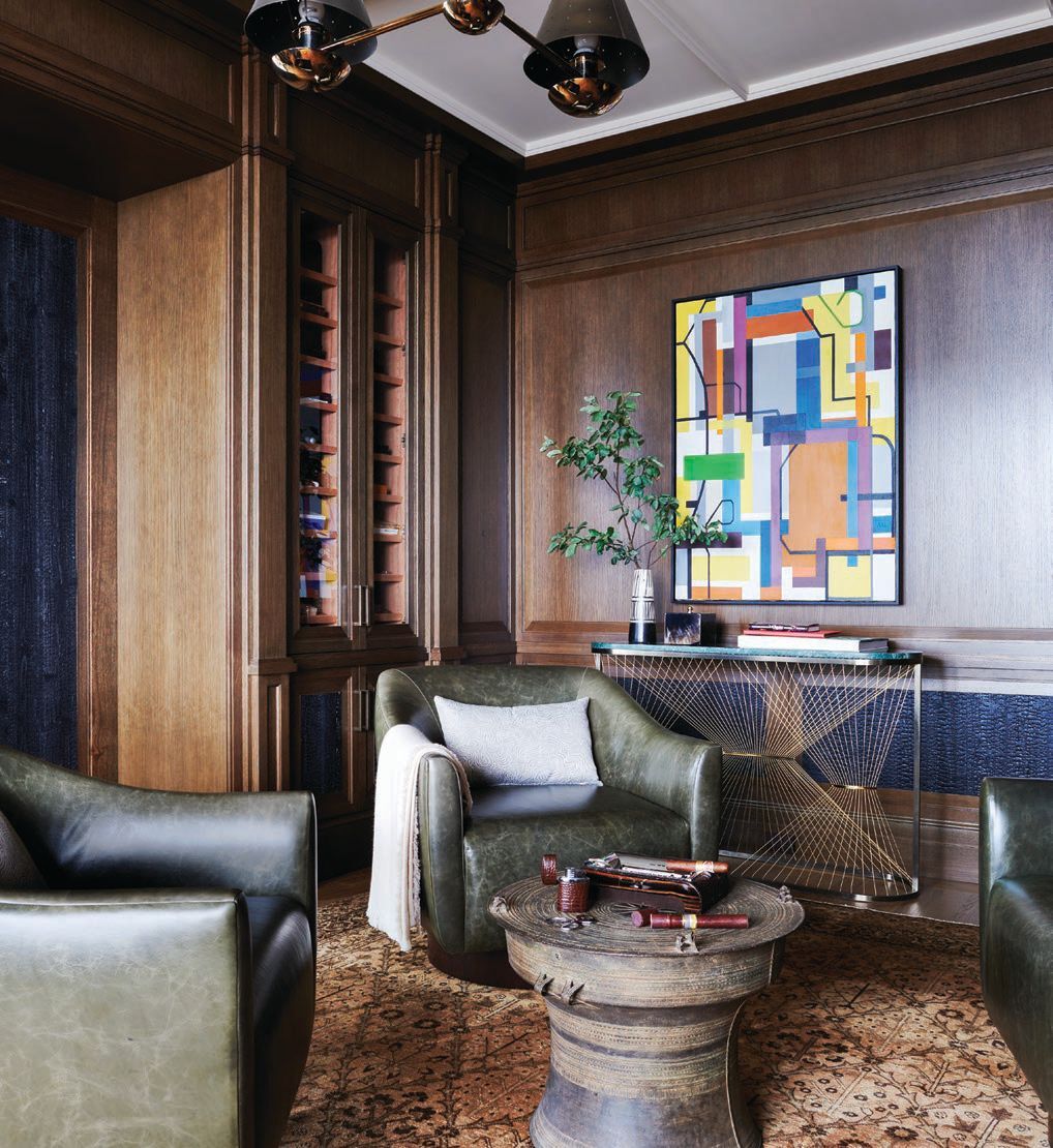 In the cigar room, an artwork by Anne L. Lehman pops against custom swivel chairs upholstered in distressed leather by Keleen Leathers and a circa 1920s antique Persian Tabriz rug from Nazmiyal Collection in New York Photographed by Richard Powers