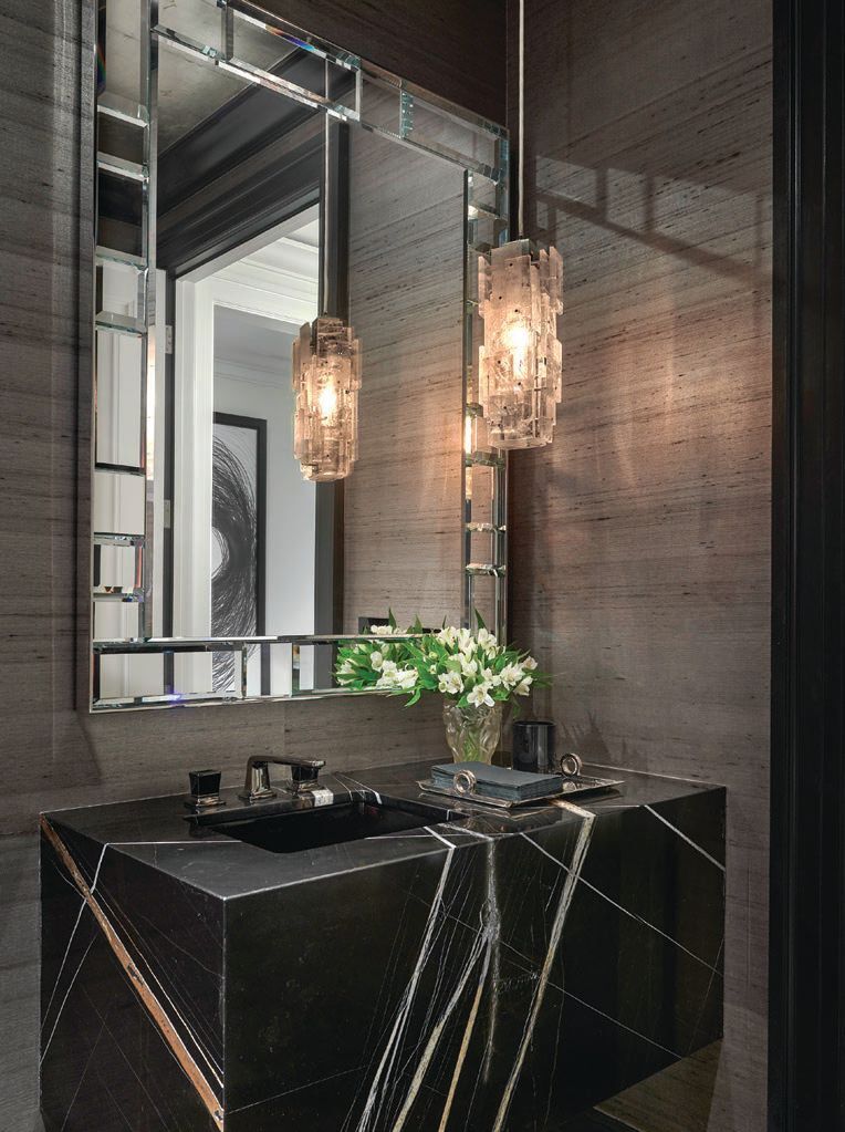 Highlights of the powder room include a rock crystal pendant by Pagani Studio, floating vanity in Sahara Noir polished marble fabricated by Hardroc Inc., and Pave mirror by Magni Home Collection  PHOTOGRAPHED BY TONY SOLURI