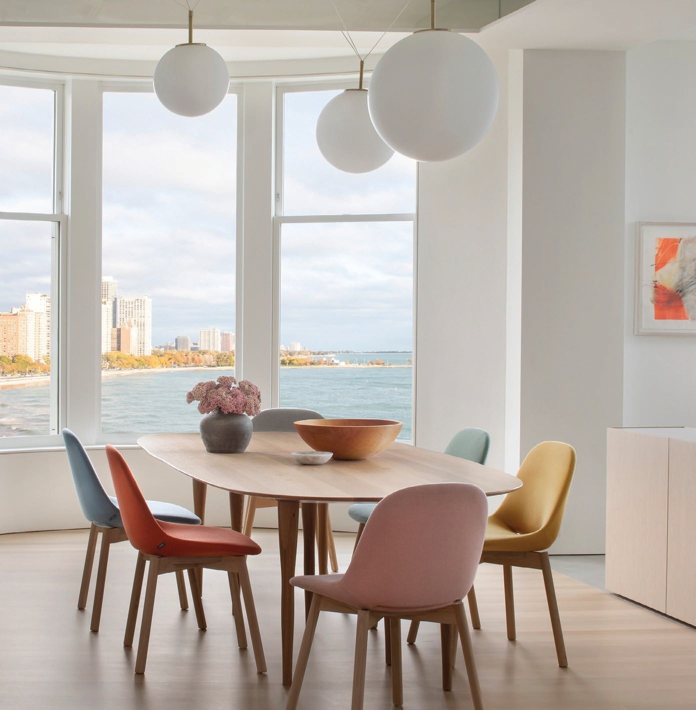 With a custom table fabricated by Peter Chasak, Artifort Beso chairs by Interni and the Pallatre three-light suspension chandelier by Vesoi from Lightology, the modern, minimalist dining room allows the sweeping Lake Michigan views to shine. Photographed by Gibeon Photography